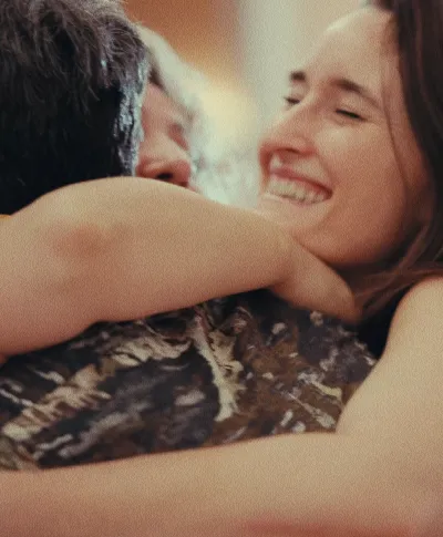 Primer plano de Cristina Carpintero sonriendo con felicidad mientras abraza a Sera Galiano y una de las clientas para la que han trabajado, transmitiendo una emoción de alegría y complicidad que se genera en un proyecto.