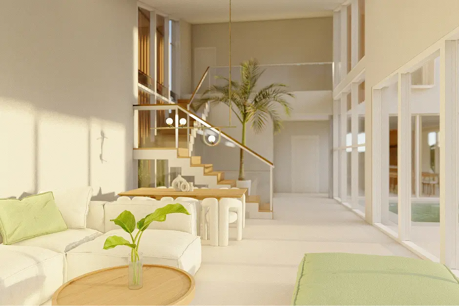 Salón amplio y luminoso, con paredes y muebles blancos combinados con plantas y madera. El sofá tiene cojines verdes y hay una alfombra a juego. Cuenta con una escalera de madera clara, una planta alta de interior y grandes ventanales desde donde se ve la piscina exterior. Ambiente luminoso y moderno.